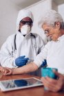 Badante facendo iniezione per il paziente anziano a casa — Foto stock