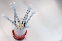 Сверху связка шприцов с гормональными препаратами размещена в контейнере на столе в лаборатории клиники фертильности — стоковое фото