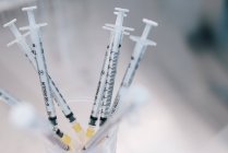 D'en haut tas de seringues avec des médicaments hormonaux placés dans un récipient sur la table dans le laboratoire de la clinique de fertilité — Photo de stock
