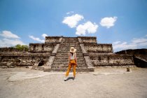 Анонімна жінка - мандрівниця, яка дивиться на стародавній будинок у сонячний день у Мексиці. — стокове фото