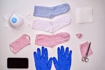 Ansicht von Socken Handschuhe Smartphone Serviette und Schere Stoffmaske während der Quarantäne von Coronavirus zum Schutz zu machen — Stockfoto