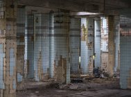 Concrete walls and remains of stairways in old abandoned industrial building with messy ground — Stock Photo
