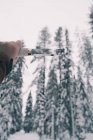 Mano masculina sosteniendo cuchillo profesional en el bosque de invierno nevado - foto de stock