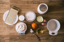 Vue de dessus de balance électronique avec farine de blé et ingrédients pour de délicieux muffins maison aromatiques dans la cuisine — Photo de stock