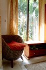 Intérieur de la chambre avec fauteuil confortable en osier avec coussins — Photo de stock