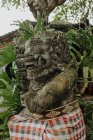Low angle of statue of Demon surrounded by green tropical foliage in Bali — Stock Photo