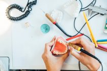 De cima de estudante de cultura com modelo dental artificial e treinamento de aprendizagem bur em tratamentos dentários durante a aula em laboratório — Fotografia de Stock