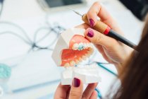 Von oben der Pflanzenschüler mit künstlichem Zahnmodell und Bohrerlerntraining in zahnärztlichen Behandlungen während des Unterrichts im Labor — Stockfoto