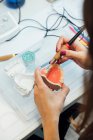 Dall'alto di studente di coltura con modello dentale artificiale e bur formazione in trattamenti dentali durante la lezione in laboratorio — Foto stock