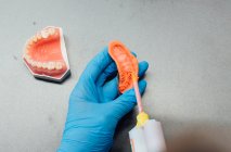 Dall'alto vista posteriore di ortodontista maschile coltura utilizzando attrezzature professionali mentre si lavora con getto dentale in laboratorio moderno — Foto stock