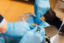 De cima de professor de odontologia colheita ajudando estudante na realização de operação enquanto trabalhava com simulador dentário em laboratório moderno — Fotografia de Stock