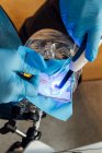 Зверху вчитель сільськогосподарської стоматології допомагає студенту виконувати операцію під час роботи з стоматологічним симулятором в сучасній лабораторії — стокове фото
