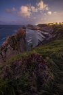 Magnifico scenario di costa rocciosa dell'oceano con rocce ruvide e acque calme sotto il cielo maestoso al tramonto — Foto stock