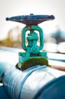 Row of colored metal faucets with valves and pipes transferring hot and cold water on plant — Stock Photo