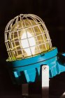 Стара промислова блискавка з яскравою лампочкою, захищена металевою сіткою і поміщена в підвал рослини — стокове фото