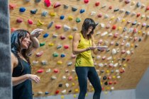 Strong happy smiley women standing resting with hands covered in chalk powder during training in climbing gym — Stock Photo