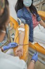 Crop specialista medico femminile in guanti di lattice che esegue l'iniezione con siringa a paziente anonimo durante la procedura di trasfusione di sangue in ospedale — Foto stock