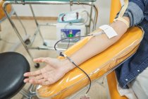 Colheita de voluntário feminino anônimo dando sangue para salvar a vida no moderno centro de transfusão de sangue — Fotografia de Stock