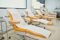 Пустые медицинские кресла, приготовленные для доноров в современном центре переливания крови с современным оборудованием — стоковое фото