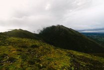 Живописный вид на зеленые холмы с низкими облаками — стоковое фото