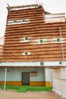Das Äußere eines Wohnhauses mit traditionellen Ornamenten an der Fassade befindet sich in der Nähe entfernte Person am grauen Tag auf der Stadtstraße — Stockfoto