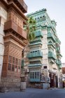 Низкий угол каменных зданий с потрепанными стенами и балконами на улице Джидды в Саудовской Аравии — стоковое фото