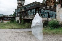 Прозрачный призрак рядом со старым заброшенным шахтным зданием с ржавыми металлическими конструкциями и обветшалыми стенами — стоковое фото