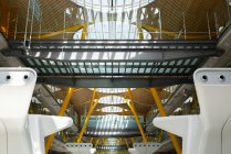 Internationaler Flughafen mit Metallbereich für die Gepäckausgabe und massiven Konstruktionen im futuristischen Stil, die von Sonnenlicht beleuchtet werden — Stockfoto