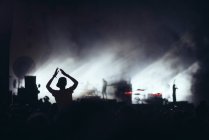 Силуети людей на фоні освітлення сцени світла під час виконання музики — стокове фото