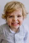 Criança adorável vestindo camisa casual sorrindo e sorrindo enquanto olha para a câmera no fundo branco do estúdio — Fotografia de Stock
