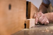 Niedrige Nahaufnahme unkenntlich Tischlermeister Fräsen Holz mit modernen elektrischen Maschine in Licht zeitgenössische Werkstatt — Stockfoto