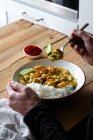 Tiro recortado del hombre con porción de gambas al curry con arroz - foto de stock