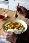 Colpo ritagliato di uomo con porzione di gamberetto al curry con riso — Foto stock