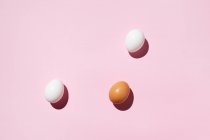 Brown and white eggs on pink background — Stock Photo