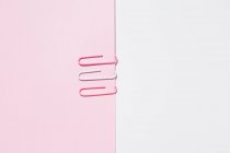 Top view of white and pink paper clips arranged on colorful background showing concept of uniqueness — Stock Photo