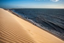 Sanddüne und Surfwellen im hellen Sonnenlicht — Stockfoto