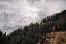 Unrecognizable hiker standing on country meadow and admiring view — Stock Photo