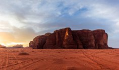 Puesta de sol vista del paisaje desierto de arena roja con montañas rocosas - foto de stock