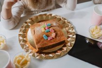 Vue du dessus du gâteau d'anniversaire savoureux décoré de bonbons à la bougie et à la gelée placés en forme de numéro cinq sur la table dans la chambre — Photo de stock