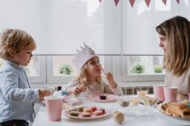 Жінка ділиться солодким шоколадним десертом з прапором на рожевій тарілці з дітьми вдома — стокове фото