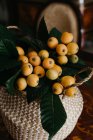 Плетений кошик зі свіжими фруктами і зеленим листям — стокове фото