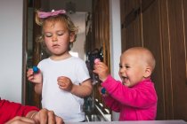 Niedliche fröhliche kleine Kinder in lässiger Kleidung spielen mit Knetmasse, während sie Zeit zu Hause verbringen — Stockfoto