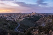 Erstaunliche Drohnen-Ansicht der alten Stadt mit alten Gebäuden, die bei Sonnenuntergang glühen und leuchtende Autobahn in Langzeitbelichtung — Stockfoto