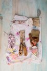 From above of shabby paintbrushes and metal scrapers placed on stained napkin — Stock Photo