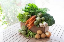 De cima da colheita de várias verduras maduras colocadas na caixa de madeira no jardim — Fotografia de Stock