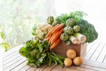 Сверху урожая различные спелые овощи помещаются в деревянную коробку в саду — стоковое фото