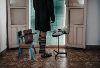 Tiro recortado de homem com máscara caixa de papelão vestindo meias listradas em pé por máquina de escrever retro — Fotografia de Stock