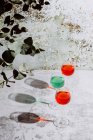 Окуляри, наповнені барвистими рідинами на бетонній поверхні в яскравому сонячному світлі — стокове фото