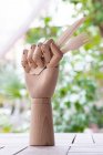 Creative mannequin hand with disposable fork and knife garnished with sprig of green parsley placed on table in garden — Stock Photo