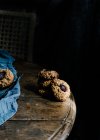 Desde arriba de deliciosas galletas de cereza horneadas colocadas sobre una mesa de madera con un trozo de tela y hierro vintage - foto de stock